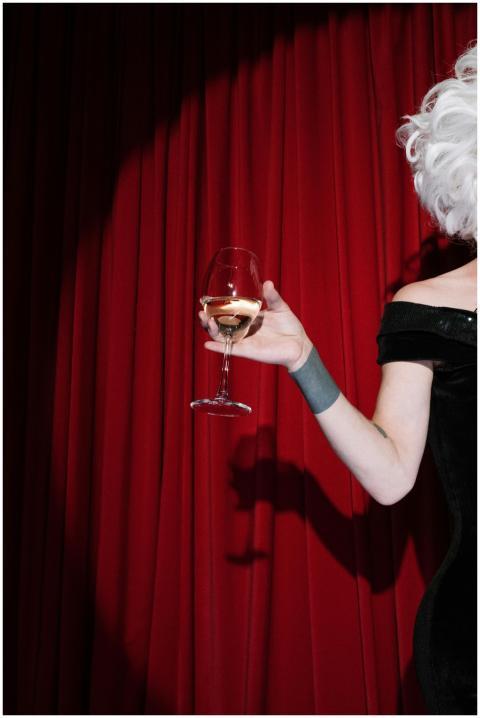 A glamorous performer with a white wig holding a g