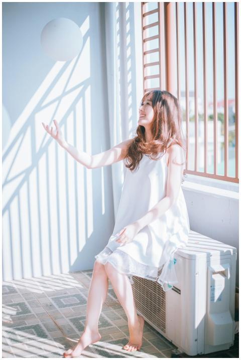 A young woman in a white dress enjoying playful su