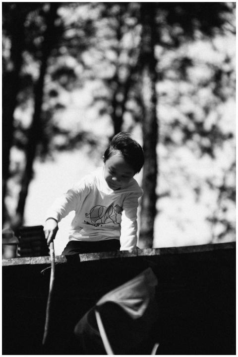 A cheerful child playing outdoors with trees in th