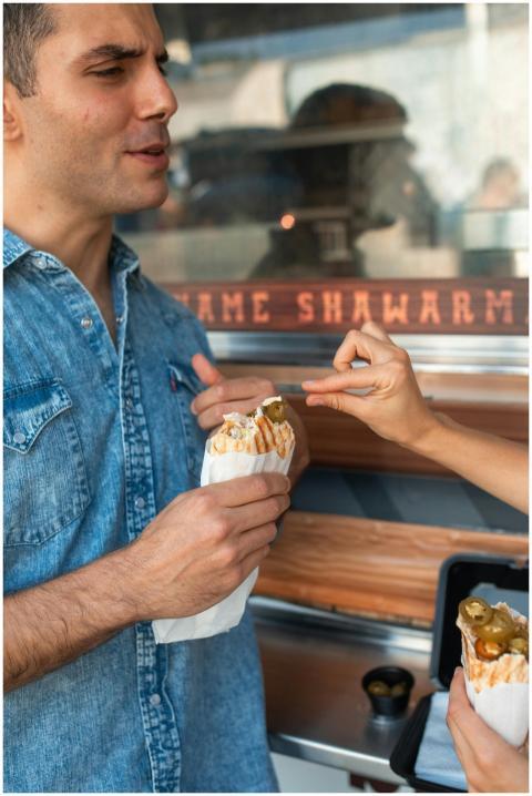 A man enjoying shawarma outdoors at a food truck,