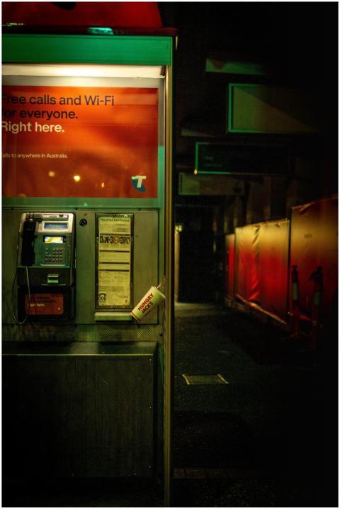 Night view of an illuminated phone booth in Brisba