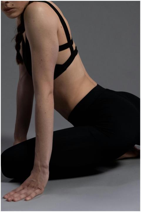 A woman in a yoga pose wearing sportswear on a neu