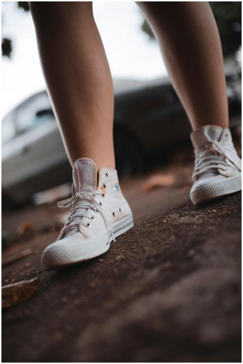 Stylish white sneakers on an outdoor city sidewalk