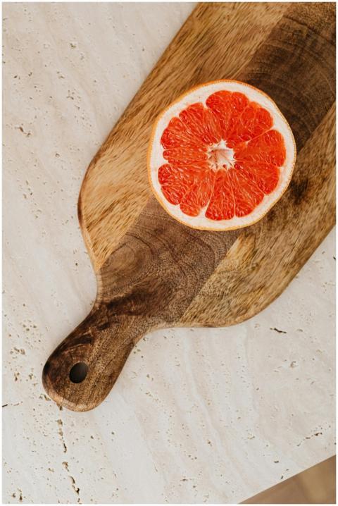 Slice of grapefruit on a rustic wooden board, perf
