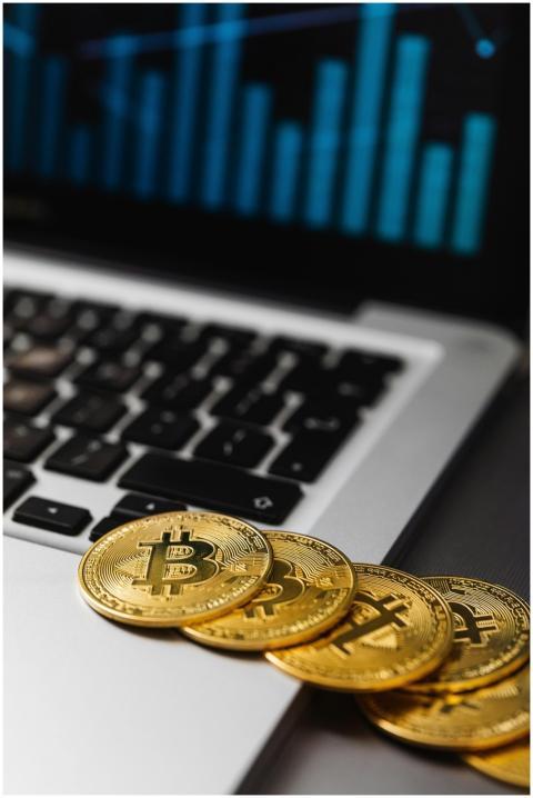Close-up of gold Bitcoins on an open laptop with f