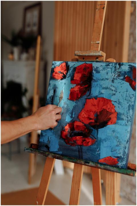 A vibrant oil painting of red poppies being create