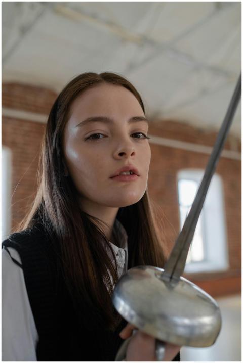 Portrait of a young woman fencer in an industrial