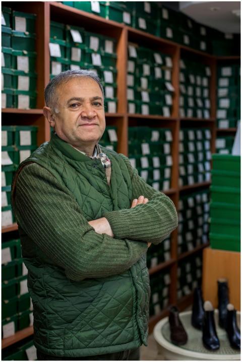 Middle-aged man standing confidently in a shoe sto