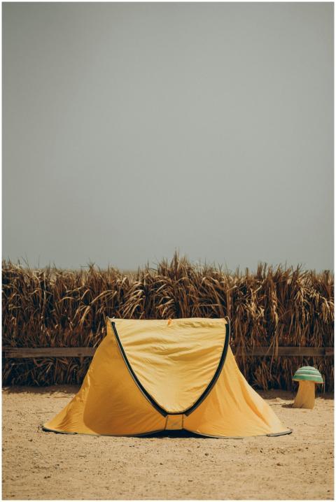 A vibrant yellow tent set against a dry landscape
