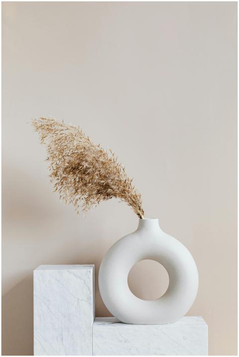 Elegant ceramic vase with dried grass on a marble