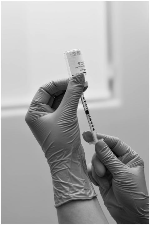 Black and white photo of gloved hands preparing a