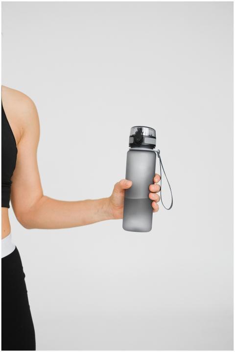 Close-up of an athletic woman holding a water bott
