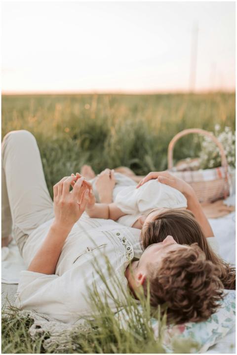 Couple enjoying a romantic picnic in a sunlit, gra