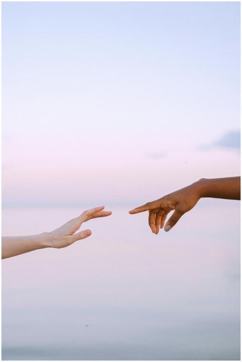 Two diverse hands reaching towards each other over