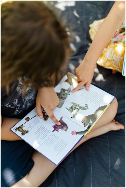 Two children reading a picture book about animals
