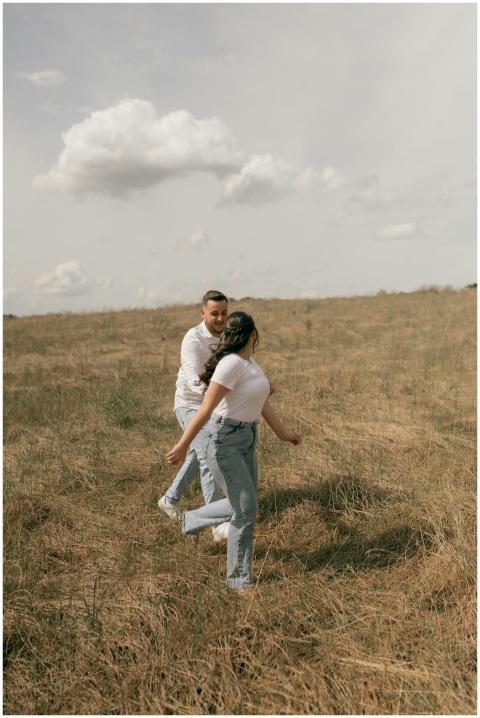 Young couple having fun in a sunlit grassy field u
