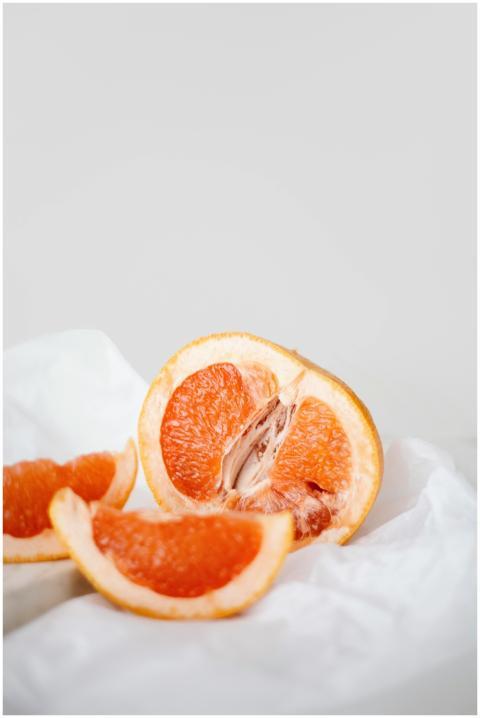 Close-up of juicy grapefruit slices on a white sur