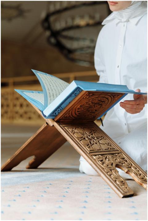 A person reads the Quran inside a mosque with intr