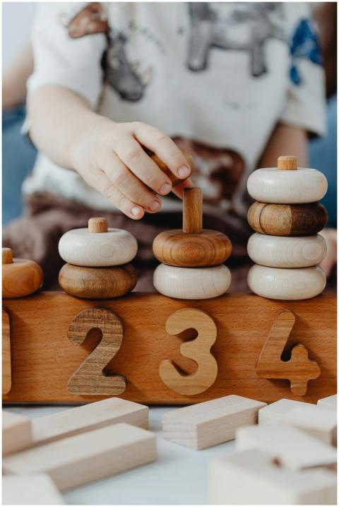 A child interacts with educational wooden number b