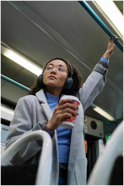 A young woman with headphones enjoys music while c