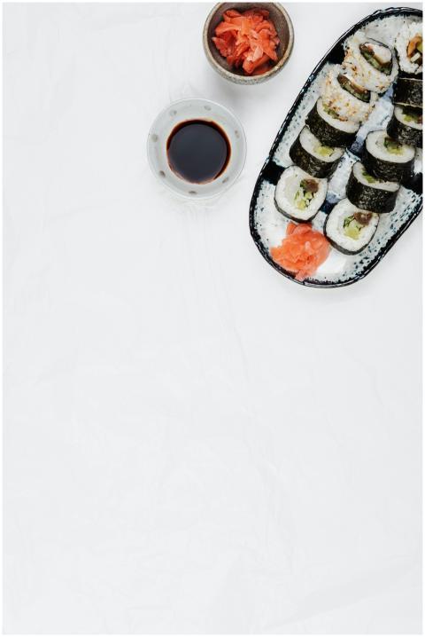 A flatlay image showcasing sushi rolls with soy sa
