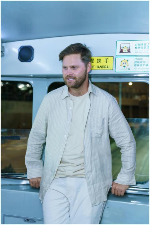 Man standing in a bus with signs in Chinese, looki
