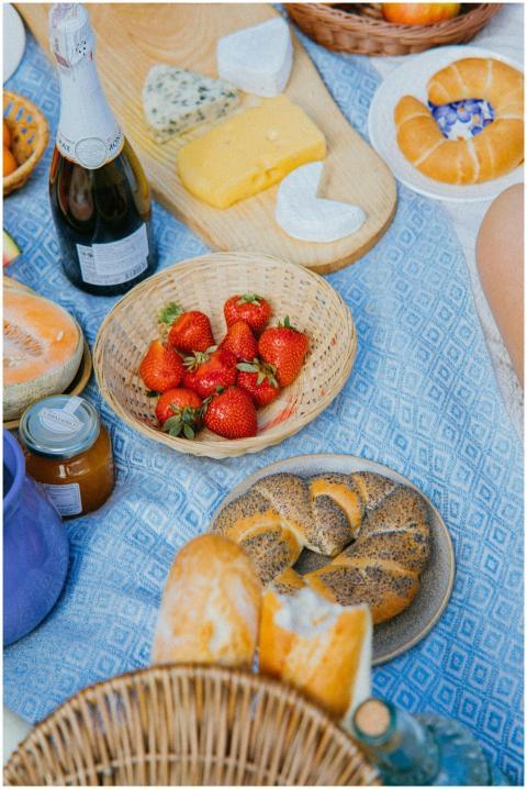 A delightful picnic setup with cheeses, strawberri