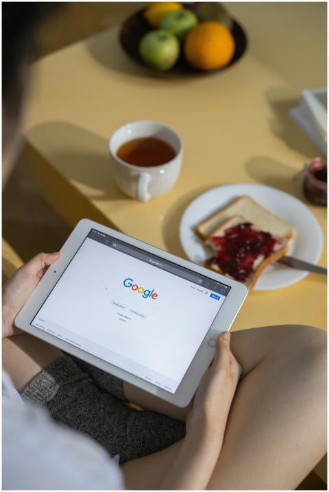 Person using a tablet with Google search open whil