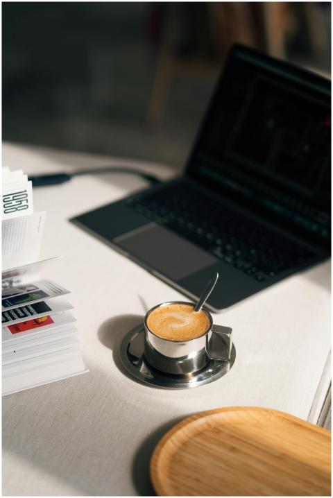 Contemporary desk setup with a laptop, coffee cup,