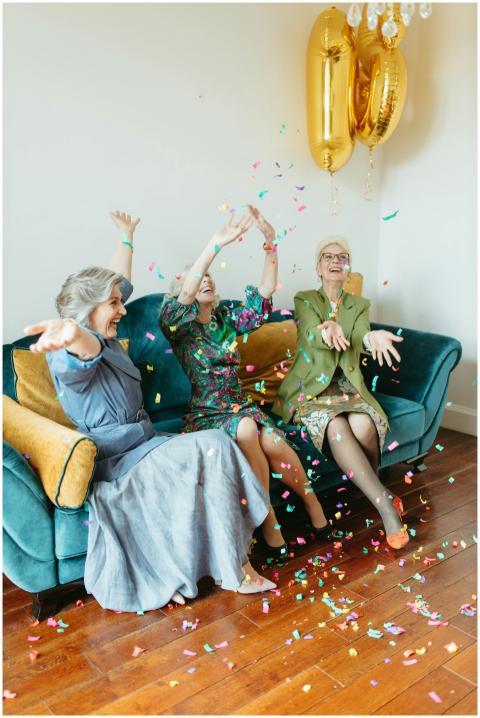 Three senior women celebrating with confetti in a