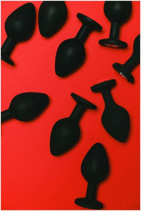 Various black silicone sex toys arranged on a vibr