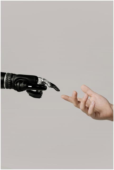 A human hand reaching to touch a bionic prosthetic