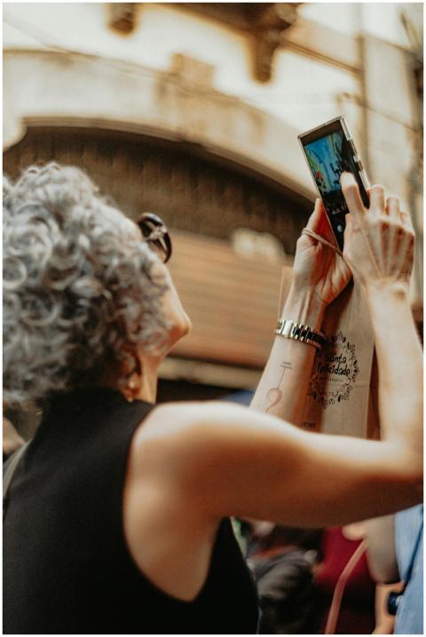 A woman with curly gray hair takes a picture using