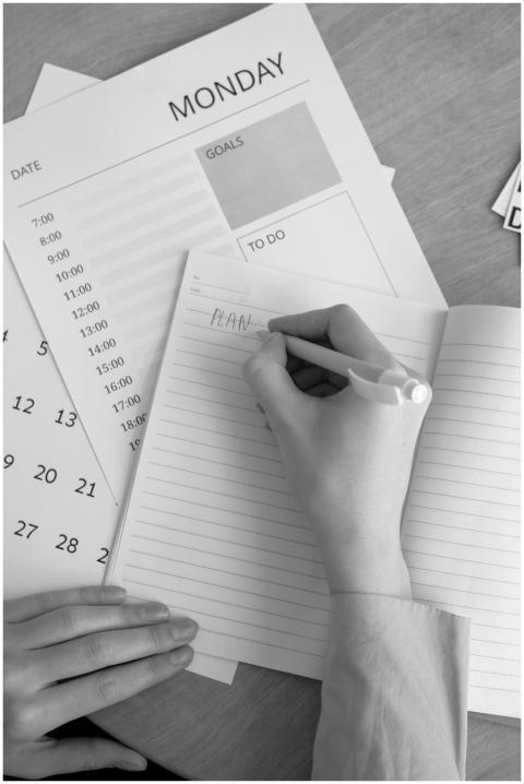 A monochrome image of a person planning their week