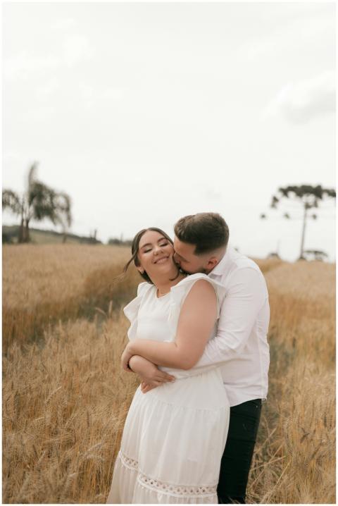 A couple sharing a tender moment in a sunny wheat