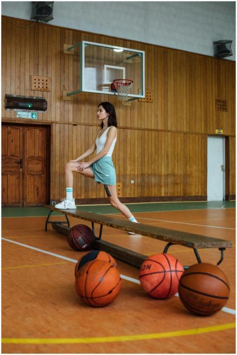 Young woman in gym attire stretching on a wooden b