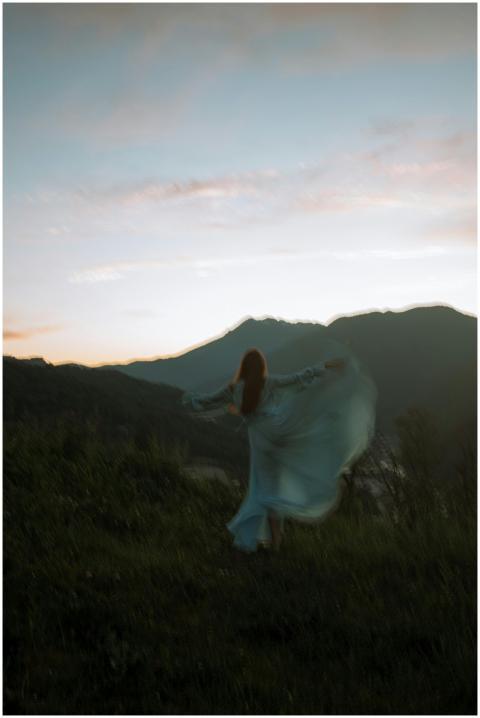 Unrecognizable woman twirls gracefully on grassy h