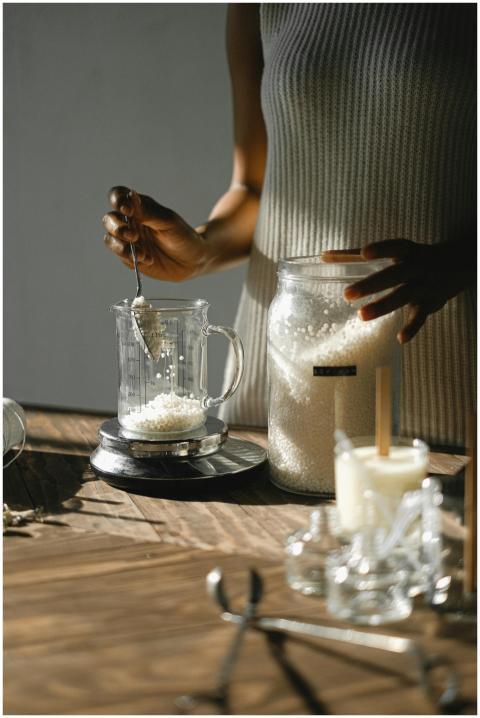 African American woman carefully measures wax gran