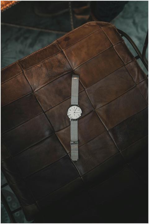 Elegant silver wristwatch resting on a brown leath