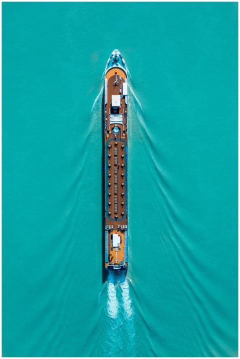 Drone shot of a cruise ship navigating turquoise w