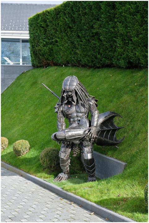 A striking metal Predator sculpture stands in a we