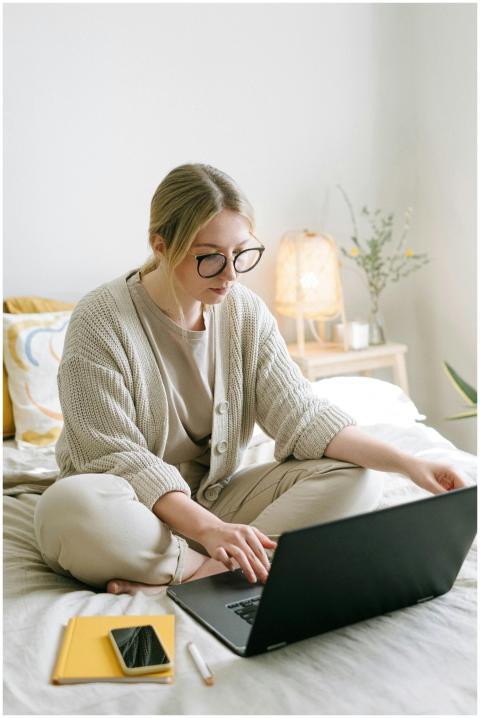 Woman in casual attire working on a laptop from a