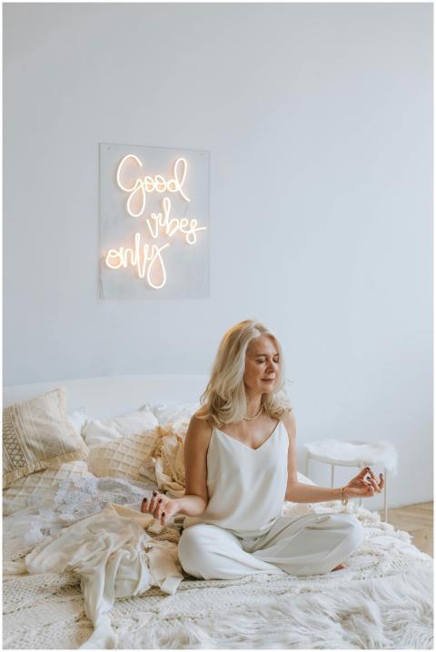 Serene woman meditating on a cozy bed under 'Good