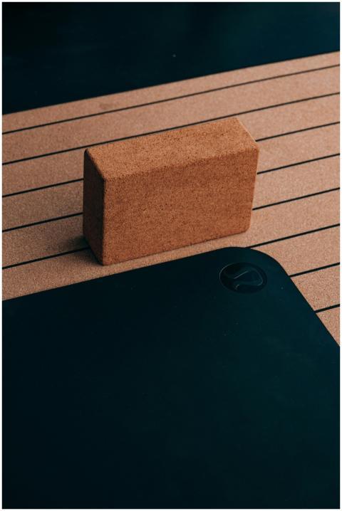 Close-up of a cork yoga block and striped yoga mat