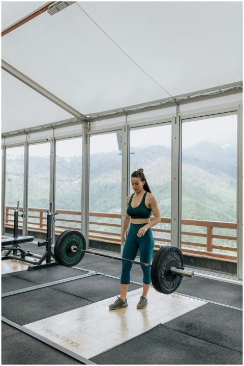 Adult woman lifting a barbell in a modern gym with