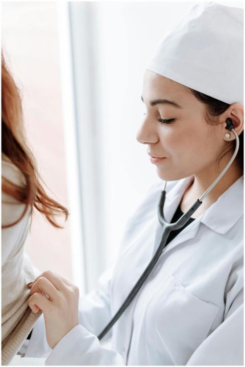Female doctor using stethoscope during medical che