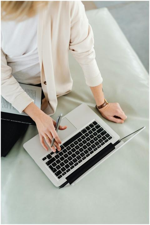 High-angle view of person working on a laptop, pen