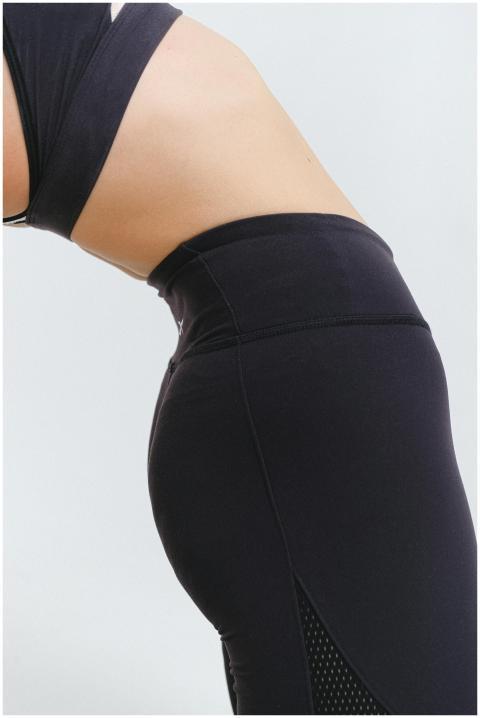 Detail of a woman in black activewear performing a
