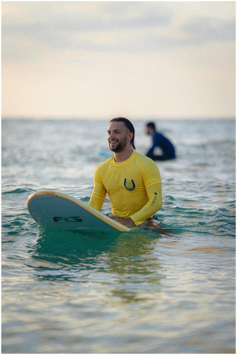 A man in a yellow wetsuit surfing at sunset in Tel