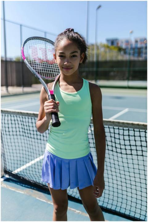 Teen girl in sportswear posing confidently with te